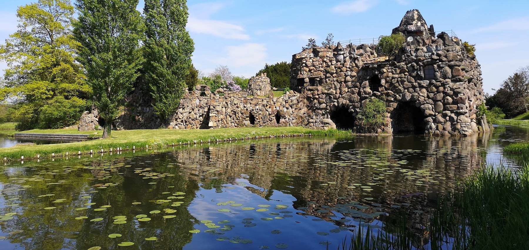 Panorama Insel Stein im Wörlitzer Park, im Vordergrund Wasser mit Seerosenblätter